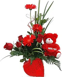 Ciotola di rose, gerbere e fiori misti dai toni caldi con pelouche