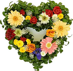 Composizione a forma di cuore di rose, gerbere e fiori misti