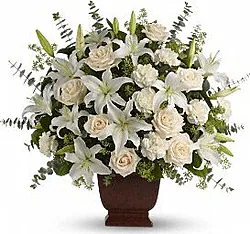 Composizione funebre di rose, gigli o lilium e fiori misti dai toni chiari