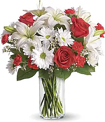Rose rosse e Lilium bianchi con fiori misti di di stagione e verde decorativo in confezione a tono.