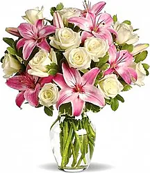 Rose Big e Lilium in Elegante Confezione a Tono con Verde Decorativo di Stagione